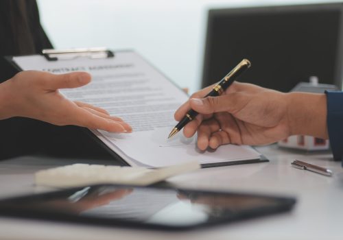 Sale representative offer house purchase contract to buy a house or apartment or discussing about loans and interest rates