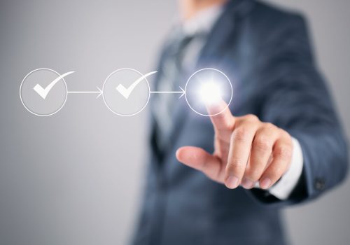 Flowchart with a businessman in the background highlighting a business process workflow and management approval.