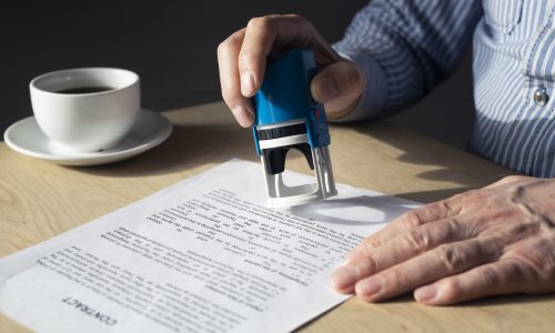 Businessman with mobile phone in hands and financial documents with numbers.